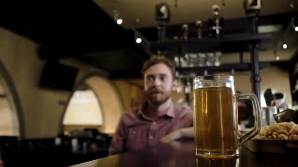 Freunde trinken Bier vom Fass und schauen Fernsehen in einer Kneipe - Filmmaterial, Video