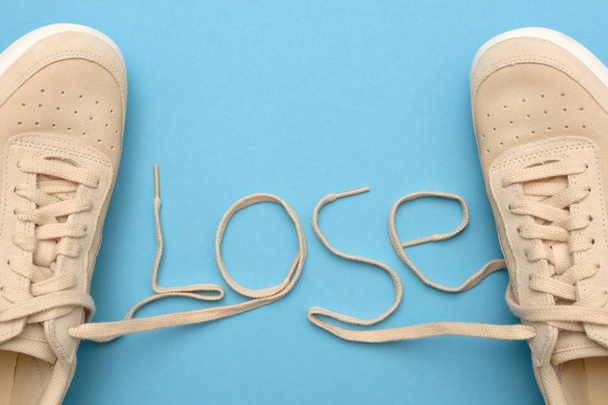 Vrouwen sneakers met veters in verloren tekst. - Foto, afbeelding