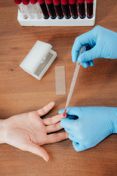 cropped view of donor and doctor obtaining blood sample - Foto, afbeelding
