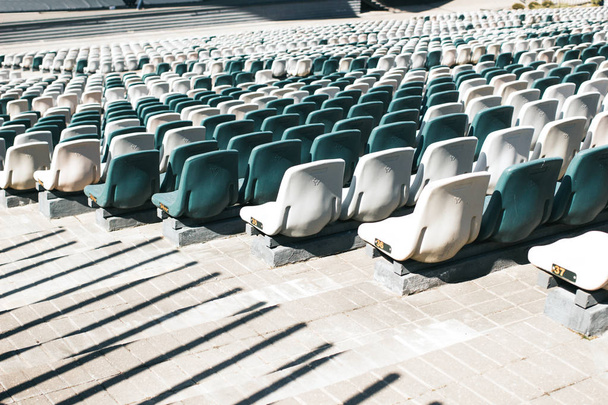 Stadion seisoo käytävät ja valkoinen ja harmaa muovi istuimet
 - Valokuva, kuva