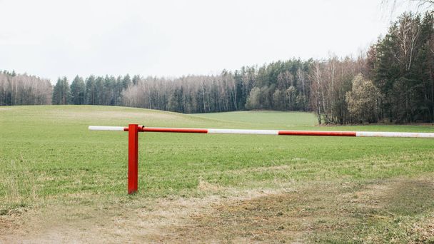 Barreira vermelha e branca fechada na entrada da floresta
 - Foto, Imagem