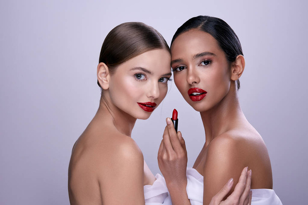 muotokuva nuoria kauniita naisia poseeraa punaisella huulipunalla
 - Valokuva, kuva