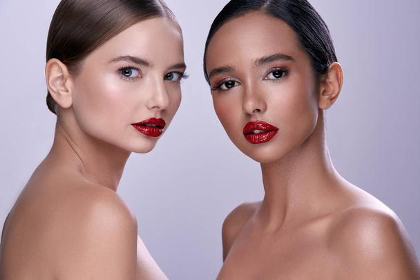 portrait of young beautiful women with red lipstick looking at camera - 写真・画像
