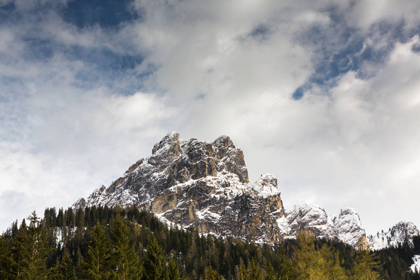 Scenic view on snowy mount peak in sunny day with blue sky and dramatic clouds in background, Italy, Dolomiti. Beautiful mountain scenery in the Alps  - Foto, Imagem