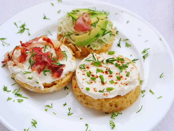 Keto-Canapes mit Frischkäse, Speck, Avocado auf Mandelbecher-Brotscheiben - Foto, Bild