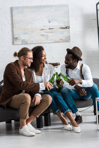 cheerful multicultural men toasting with happy african american girl in living room  - Fotografie, Obrázek