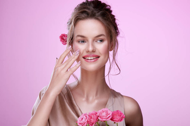 retrato de mujer joven atractiva con rosas rosadas posando sobre fondo rosa
 - Foto, imagen