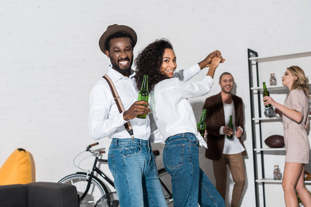 szelektív középpontjában afroamerikai férfi és nő táncol barátok közelében  - Fotó, kép