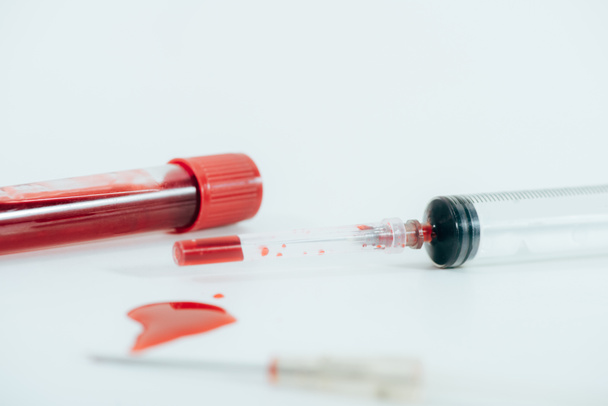 beyaz yüzeyüzerinde kan ve şırınga ile test tüpü - Fotoğraf, Görsel