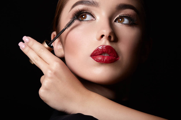 attractive young woman with evening makeup and mascara on dark background - Valokuva, kuva