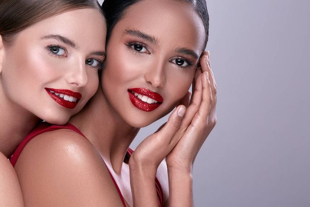 portrait of young beautiful women with red lipstick and in red clothing - Photo, Image