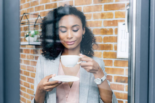 african american Casual businesswoman with coffee cup behind window - Foto, Bild
