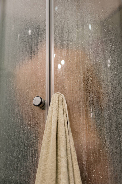 Mulher bonita no chuveiro atrás de vidro com gotas. mulher no chuveiro atrás de vidro com gotas. foto vertical
. - Foto, Imagem