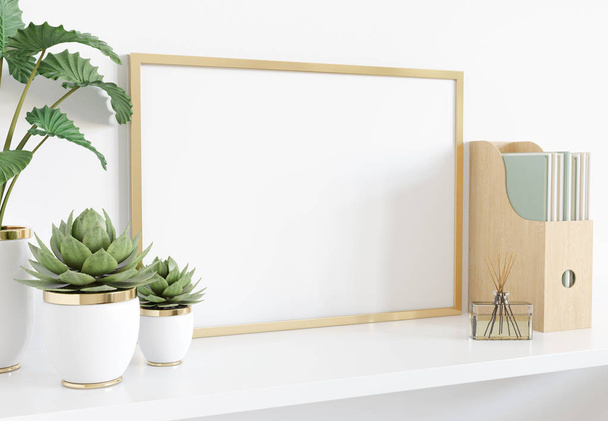 Golden frame leaning on white shelve in interior with plants and - Fotó, kép