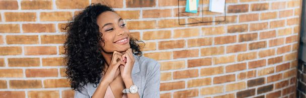 colpo panoramico di sorridente afroamericana Casual donna d'affari in loft ufficio con spazio copia
 - Foto, immagini