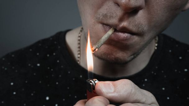 Молода людина палить медичний марихуану суглоб. Крупним планом
. - Фото, зображення