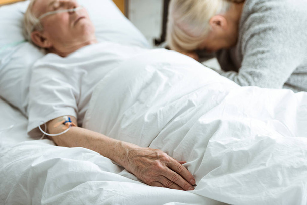 selectieve focus van Sad Senior vrouw met man in coma in kliniek - Foto, afbeelding
