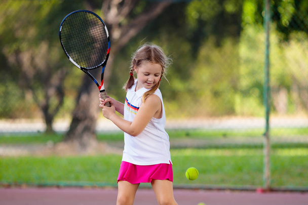 Enfant jouant au tennis sur un court extérieur
 - Photo, image