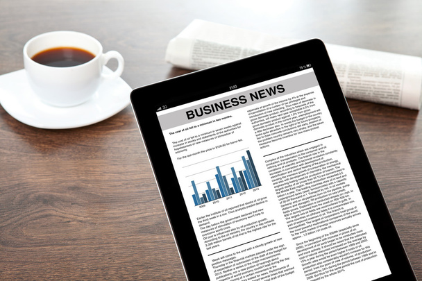 tablet with business news in a screen on a table at a businessma - Photo, Image