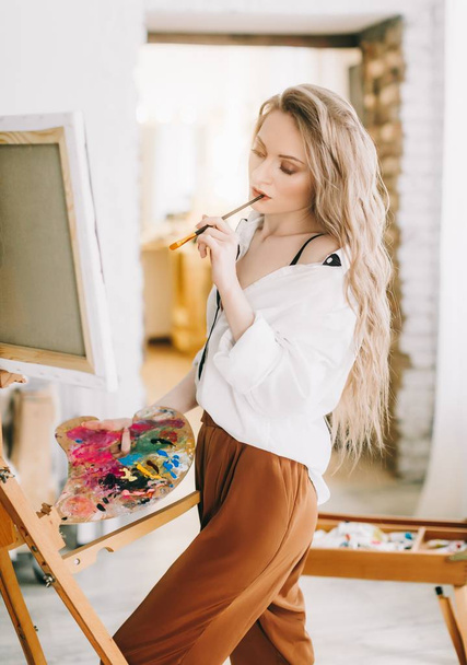 Beautiful young artist woman posing in room - Photo, Image