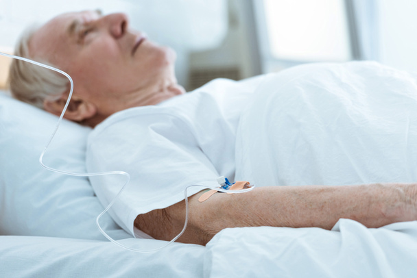 foco seletivo do homem inconsciente sênior deitado na cama no hospital
 - Foto, Imagem