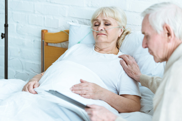 hombre mayor sujetando portapapeles con la esposa enferma en la clínica
 - Foto, imagen