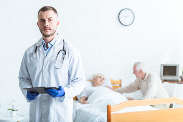 doctor holding clipboard, sick patient and senior man in clinic - 写真・画像