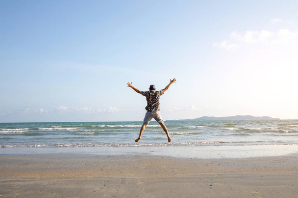 happy man freedom jump ocean sea scape background - Foto, afbeelding
