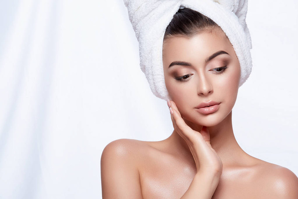 portrait of young beautiful woman with white towel on head and nude make up - Foto, afbeelding