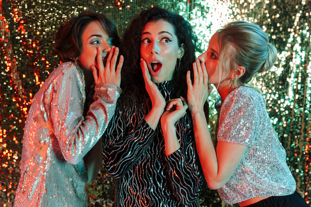 Young Three beauty women wearing in shiny clothes posing - Foto, Bild