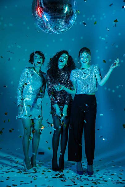 Immagine a figura intera di tre donne che indossano vestiti lucidi
 - Foto, immagini