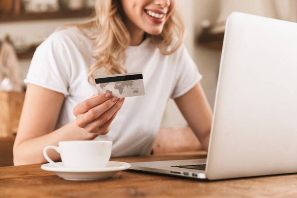 Portrait de charmante femme blonde utilisant ordinateur portable et carte de crédit fo
 - Photo, image