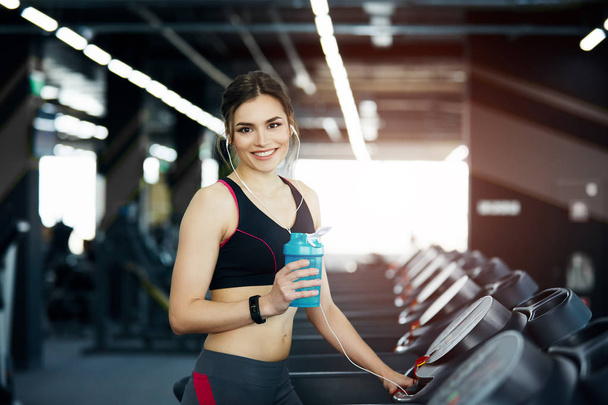 jong fit vrouw met water fles training in de sportschool - Foto, afbeelding