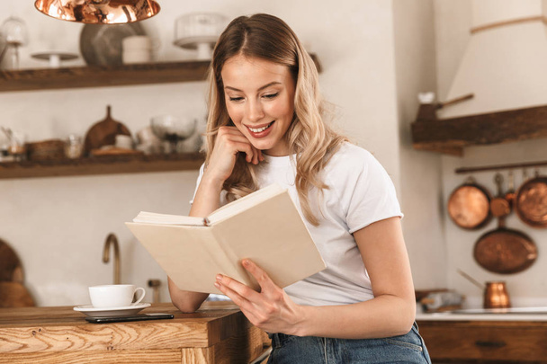 Portrait of young blond woman reading book while standing in sty - Foto, Imagem