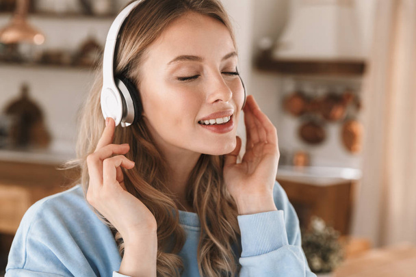 Portrait of stylish blond girl 20s wearing headphones listening  - Фото, изображение