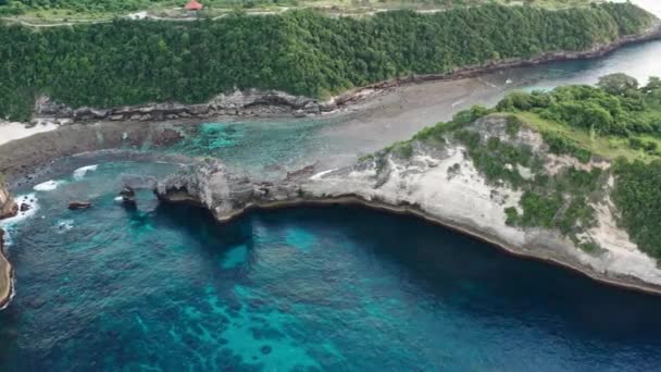 Letecký pohled na zelené tropické pobřeží ostrova Nusa Penida, Atuh Beach, Bali, Indonésie. průzračná modrá oceánská vlna se valí na pláž. 4k - Záběry, video