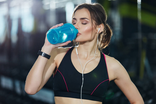 młoda kobieta fit z butelki wody szkolenia w siłowni - Zdjęcie, obraz