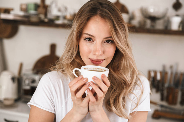 Image closeup of beautiful blond woman holding cup and drinking  - Фото, зображення