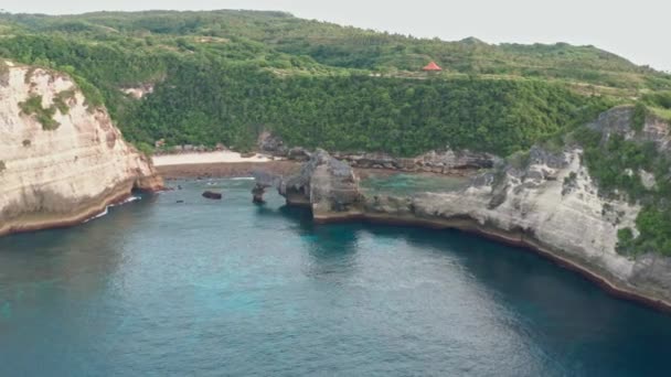 Antenni näkymä vihreä trooppinen rannikko saaren Nusa Penida, Atuh ranta, Bali, Indonesia.Clear sininen valtameri aaltoja liikkuvan rannalle. 4K
 - Materiaali, video
