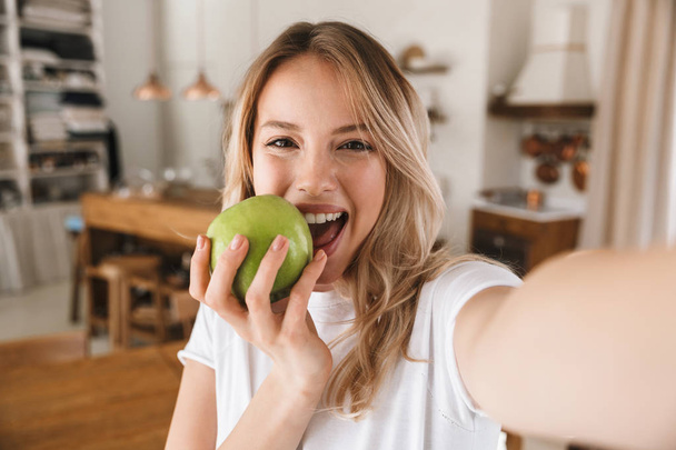 Image closeup of pretty blond woman laughing and holding green a - Valokuva, kuva