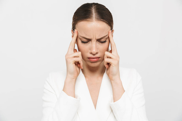 Beautiful displeased sad woman with headache posing isolated over white wall background. - Фото, изображение
