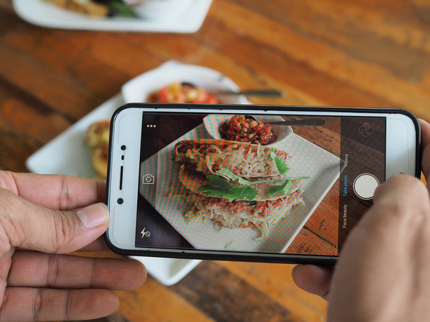 женщина рука с помощью мобильного телефона снимать итальянскую еду
 - Фото, изображение