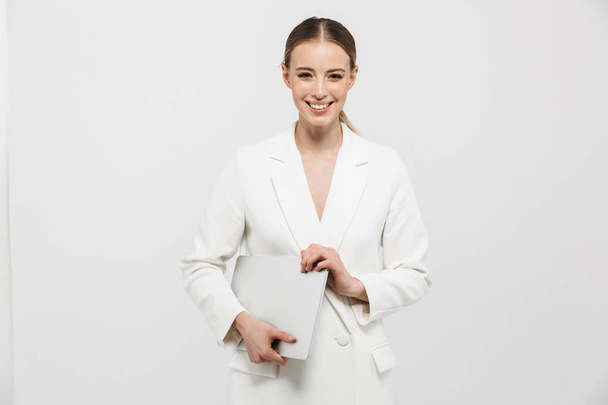 Beautiful amazing woman posing isolated over white wall background holding laptop computer. - Фото, зображення