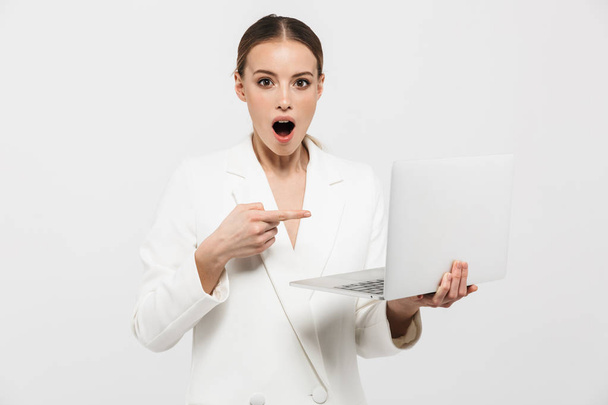 Beautiful shocked excited amazing woman posing isolated over white wall background using laptop computer. - Фото, зображення