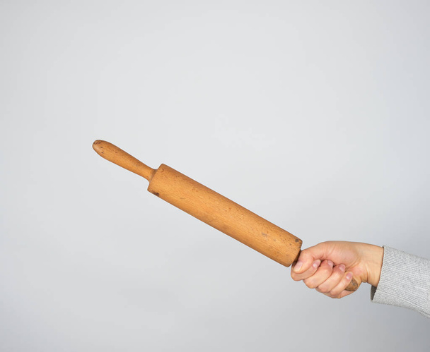 hand holding a wooden rolling pin  - Фото, зображення