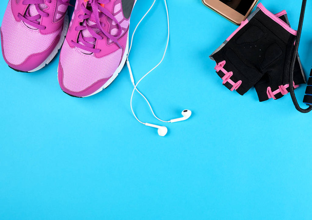 ζευγάρι ροζ αθλητικά παπούτσια με κορδόνια σε μπλε φόντο - Φωτογραφία, εικόνα