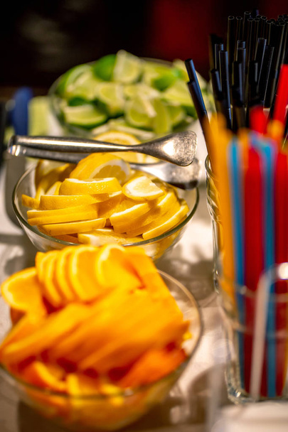 Φέτες πορτοκαλιού, λεμονιού και λάιμ στο τραπέζι του γάμου - Φωτογραφία, εικόνα