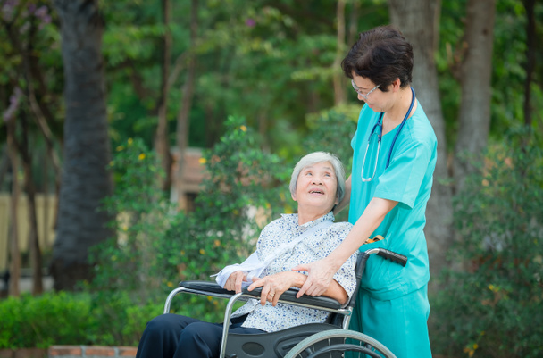 Smiling caregiver Senior nurse take care a Senior patient on whe - Photo, Image