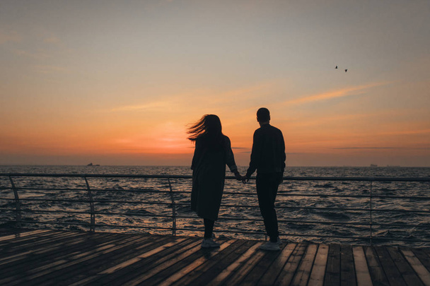 Beautiful loving couple walking at sunset - 写真・画像