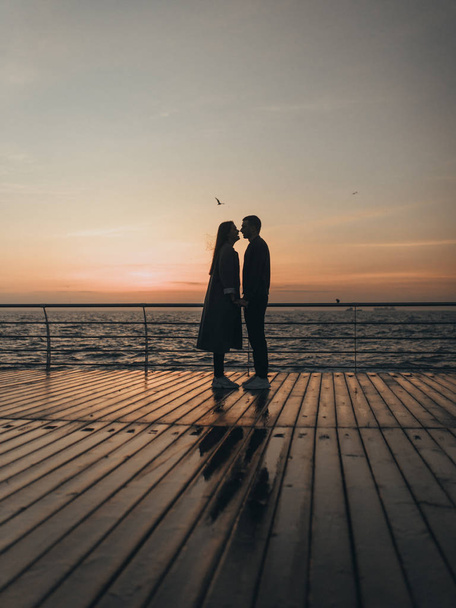 Beautiful loving couple walking at sunset - Foto, afbeelding
